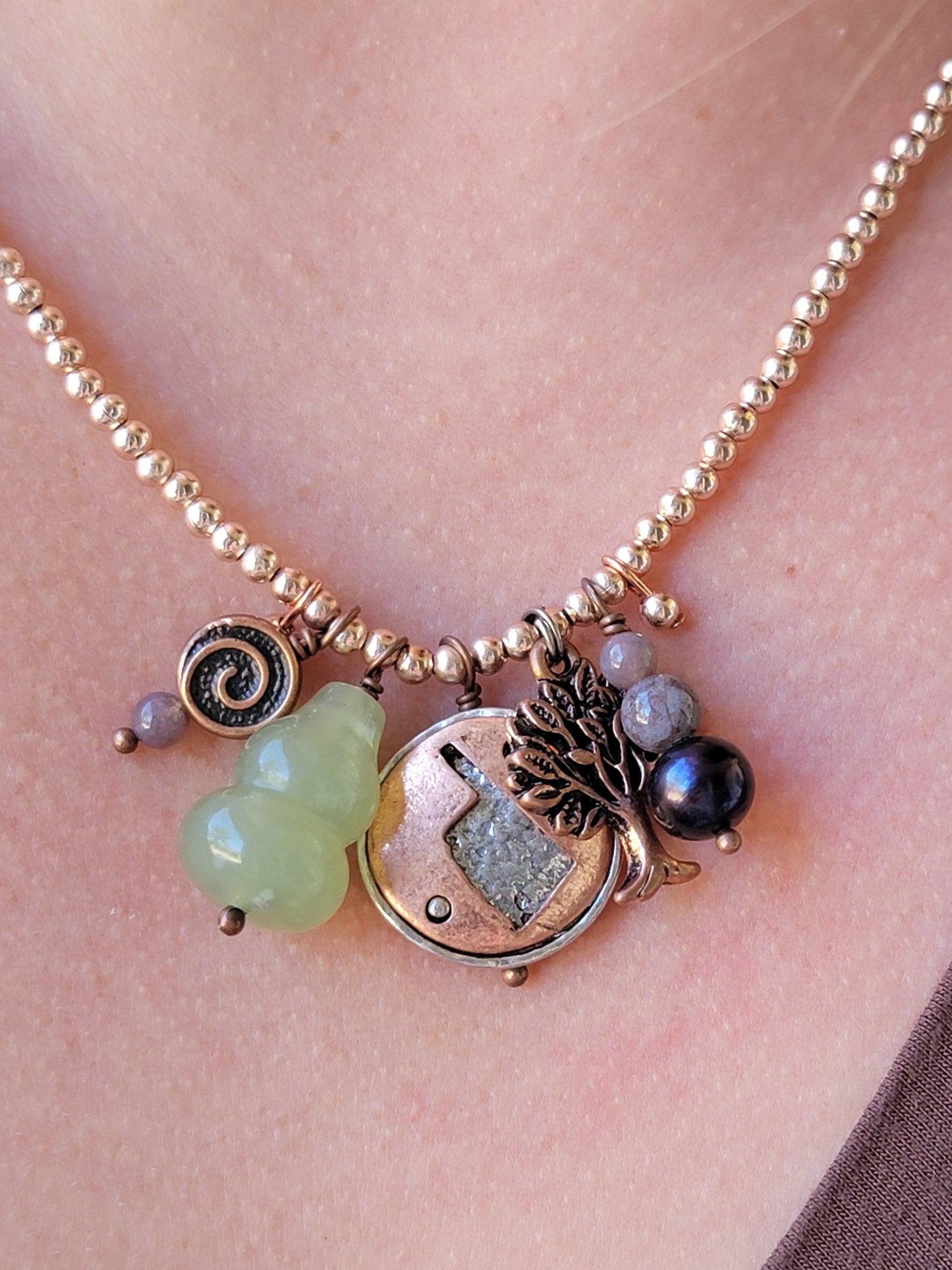 Necklace with various charms on a person's neck